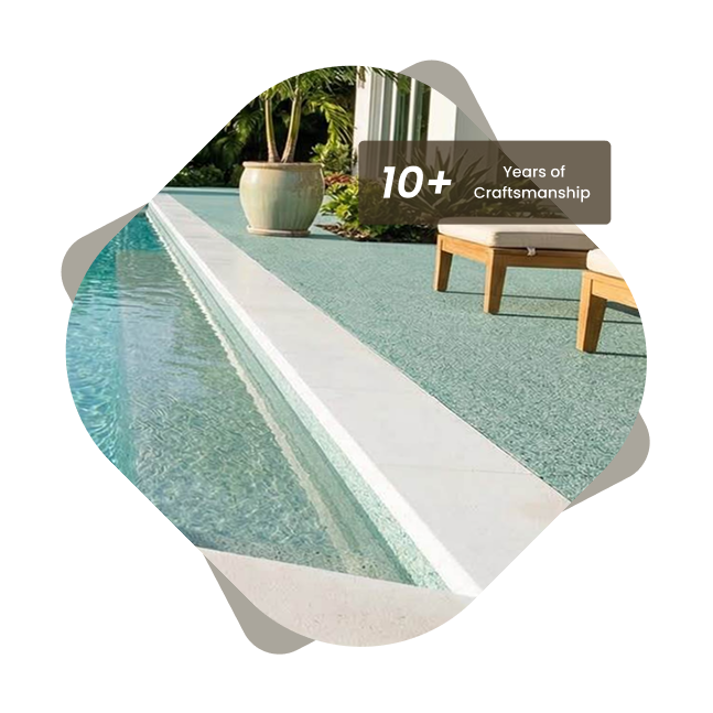 Stone carpet flooring around a swimming pool with lounge chairs